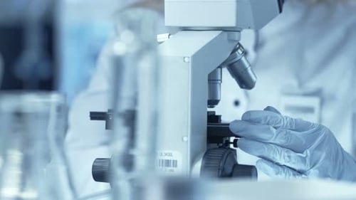 Woman Scientist Working with Microscope in Laboratory