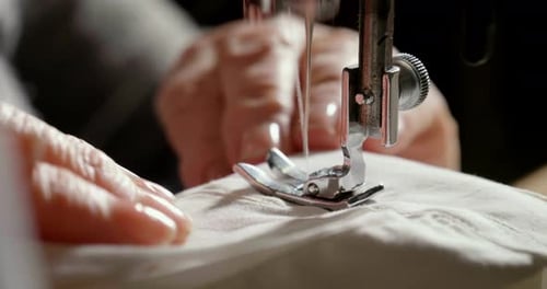 Superzeitlupe einer professionellen Nähmaschine, die mit weißem Faden näht, eine italienische Haute Co