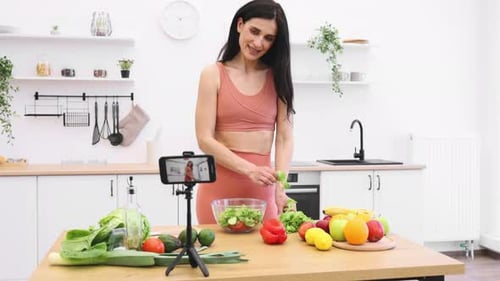 Food Blogger Adding Leafy Greens to Salad Bowl on Camera