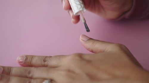 Woman Applying Clear Nail Polish Close Up