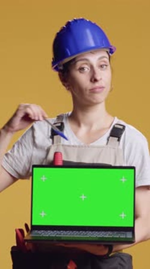 Vertical Video Portrait of Handywoman Holding Laptop with Greenscreen Display