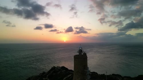 Drohnenaufnahme des Leuchtturms an den Klippen bei Sonnenuntergang