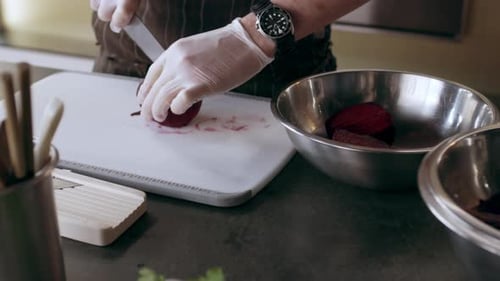 Professional chef prepares fresh beets in bright kitchen for restaurant