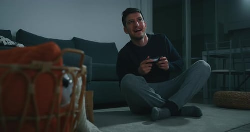 Man Playing Video Games at Home at Night
