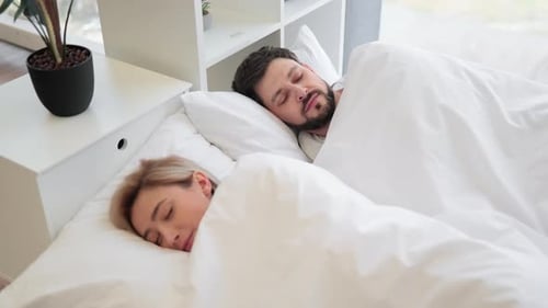 Happy Couple Sleeping in Bright White Bed