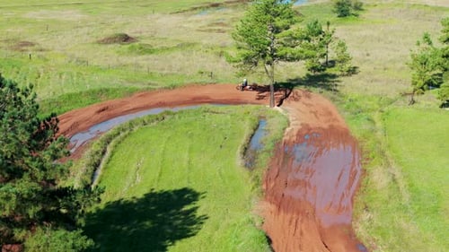 Aerial view of amateur racers practicing motocross on competition track in countryside.