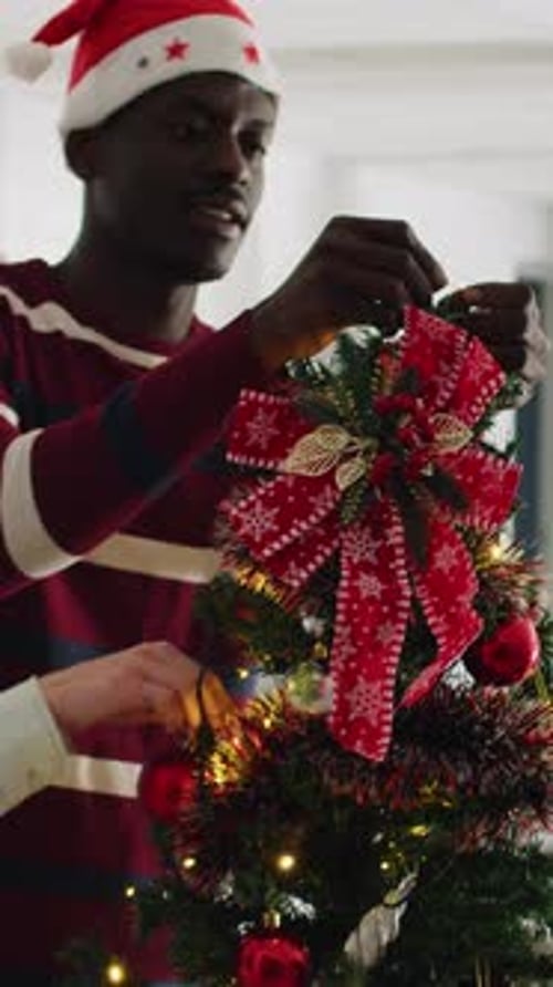 Man Decorating Christmas Tree in Office with Colleague