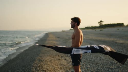 Man Holding Pirate Flag at Beach at Sunset