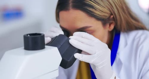 Female Scientist Works with Microscope in Laboratory