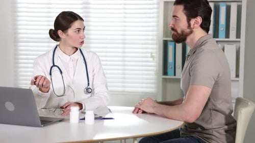 Doctor giving pills to patient at white desk indoors