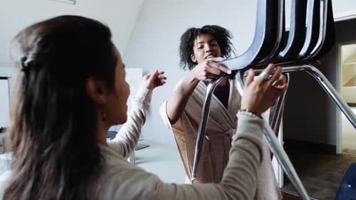 Female Activists Arranging Chairs for Meeting in Office 10 Seconds or Greater