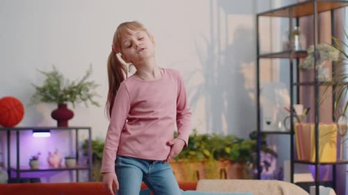 Happy Girl Dancing on Couch Indoors