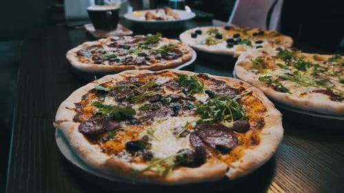 Lots of Pizzas on the Table in a Pizzeria