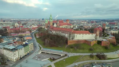 Aerial drone shot flying backwards over Vistula River, Krakow Wawel Royal Castle, city center fortre