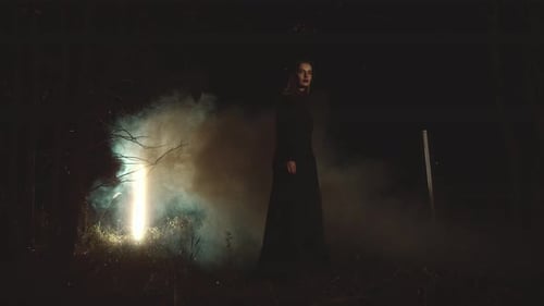 Model gracefully posing with vibrant smoke bombs in an enchanting forest setting