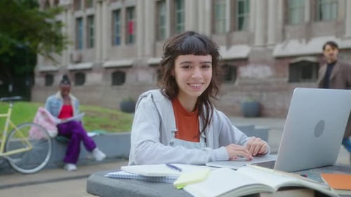 Portrait of Happy College Girl with Laptop Outdoors on Campus