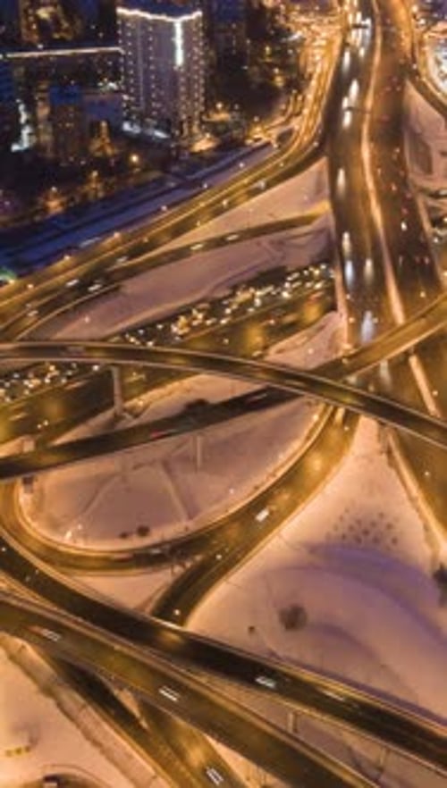 Illuminated Road Junction and Cars Traffic at Winter Night in Urban City Flyover Aerial View
