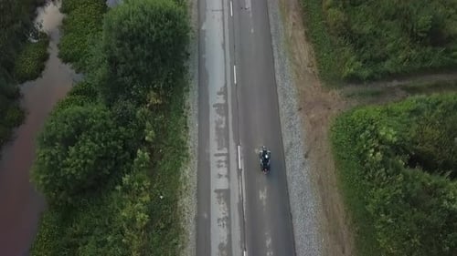 Aerial Top View of Motorcycle Riding on Rural Road Clip