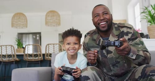 Smiling Father and Son Play Video Games