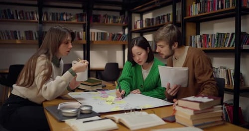 Une fille asiatique brune concentrée communique avec ses camarades tout en élaborant un plan sur un
