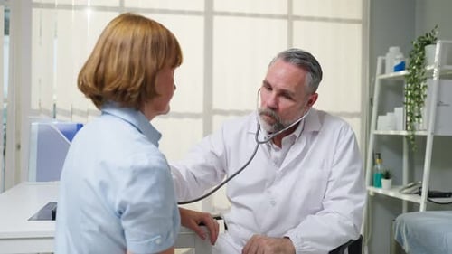 Doctor Examines Patient with Stethoscope in Office