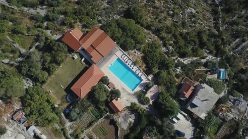 Blue water pool at holiday villa with lounging chairs on pool Terrace.