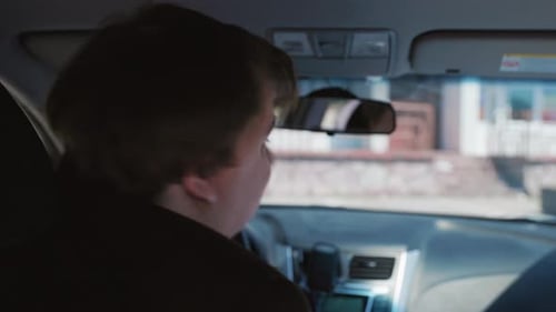 Man Driving Car Looks Over Shoulder
