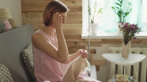 Woman Knitting Cozy Blanket at Home