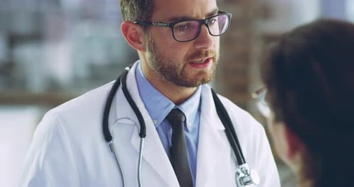 Doctor talking with a patient, showing her lab results or diagnosis on a tablet in a hospital
