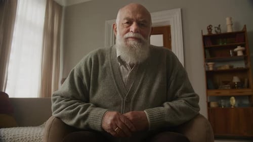 Old Man Portrait in Chair Senior Adult Looking at Camera Indoors