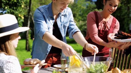 Leisure, Holidays, Eating, People And Food Concept - Happy Friends Having Dinner At Summer Garden...