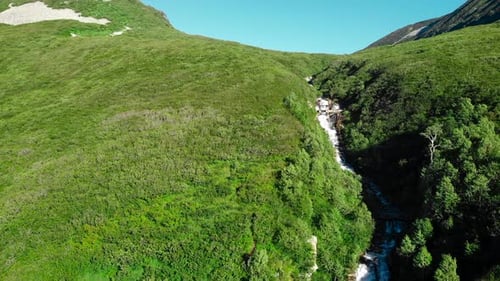 Aerial View of Waterfall in Lush Green Mountain Valley Media