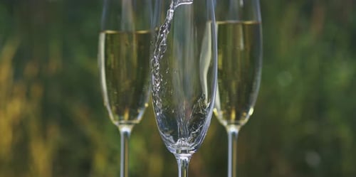 Champagne Pouring into Three Flutes Outdoors