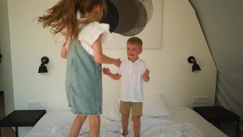 Kids Playfully Jumping on Bed in Bedroom
