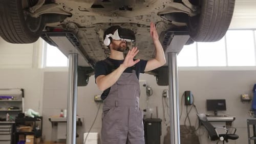 Mechaniker inspiziert Auto im Aufzug mit Virtual-Reality-Headset