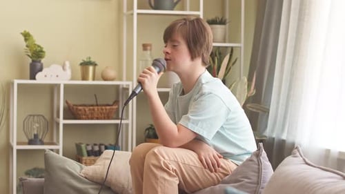Boy Singing Into Microphone At Home