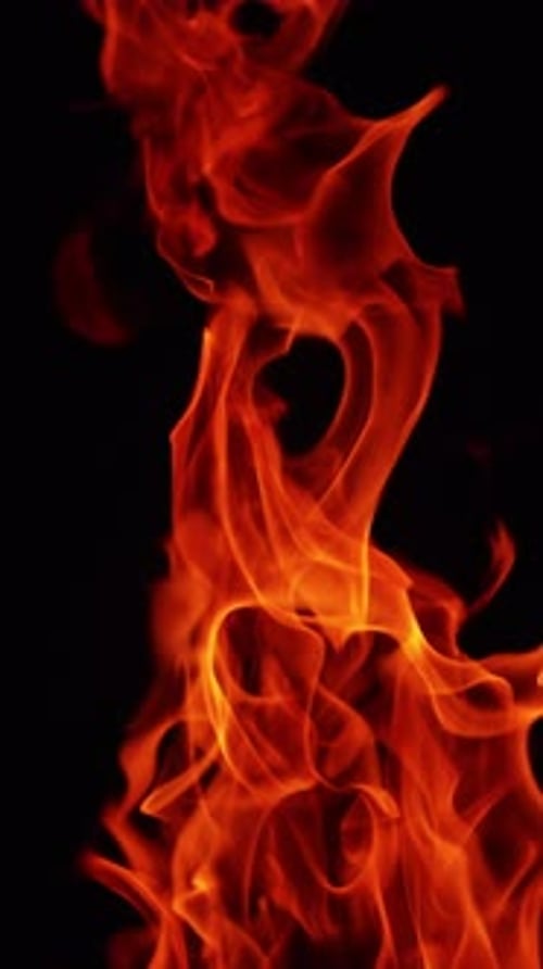 Red fire flame stretching high into the darkness.