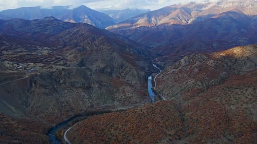 Aerial view the mountains are covered in trees and river in autumn season