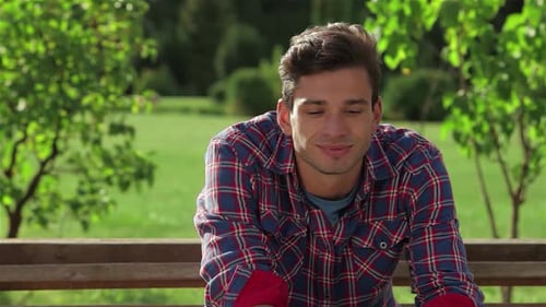 Cheerful Man Smiling Warmly at the Camera in a Vibrant Park