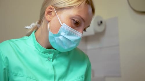 Close Up Face and Eyes Woman Doctor or Nurse Wearing Medical Face Mask Looking at Patient in
