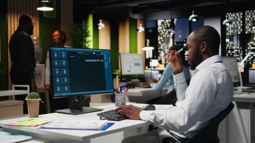 Young Man PC User Interacting with AI Chat System on Pc at Office Late at Night
