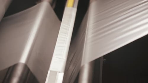 Industrial textile production, fabric moving through rollers in factory