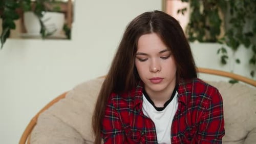 Teenage Woman Sitting Indoors With Long Brown Hair