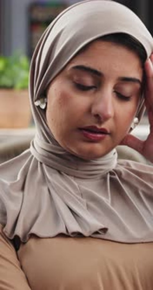 Thoughtful Woman Wearing Hijab Resting Head on Hand