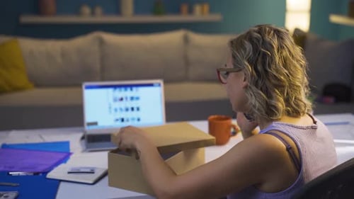 Woman Talking on Phone Opens Box