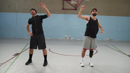 Two Athletes Do Muscle Stretching Move On Basketball Court