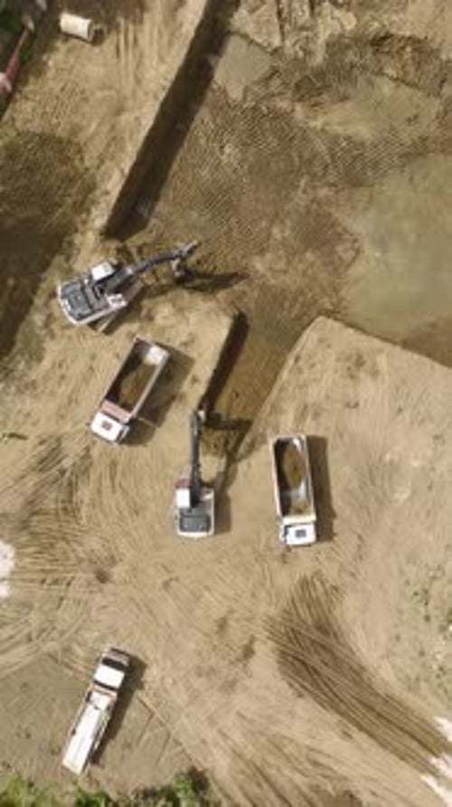 Vídeo vertical: trabajadores y maquinaria en acción en una obra de preparación de cimientos