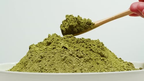 Matcha Green Tea Cooking Process Japanese Powder Green Tea in a Bowl with Bamboo Whisk Macro Close