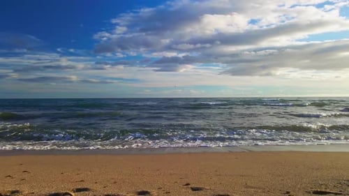 Aerial view of ocean waves from the beach into the sea in slow motion