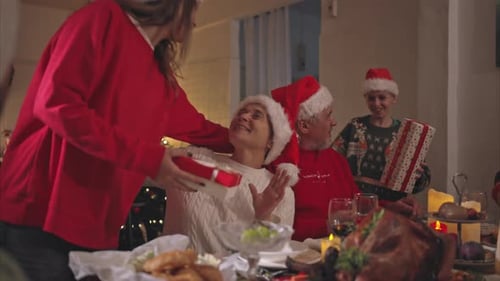 Family Exchanging Gifts at Christmas Dinner